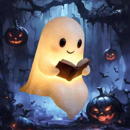Cute LED ghost night light reading a book among Halloween pumpkins, perfect bedside lamp for children's rooms.